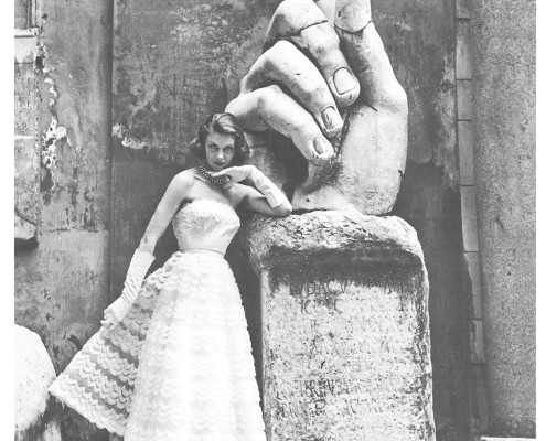 Sorelle Fontana model alongside the hand of the colossal statue of Constantine in the courtyard of the Musei Capitolini in Rome, 1952, Photo Regina Relang. Courtesy Archiv Relang, Sammlung Photographs, M.nchner Stadtmuseum. The image was part of a feature published in La Donna, June 1952