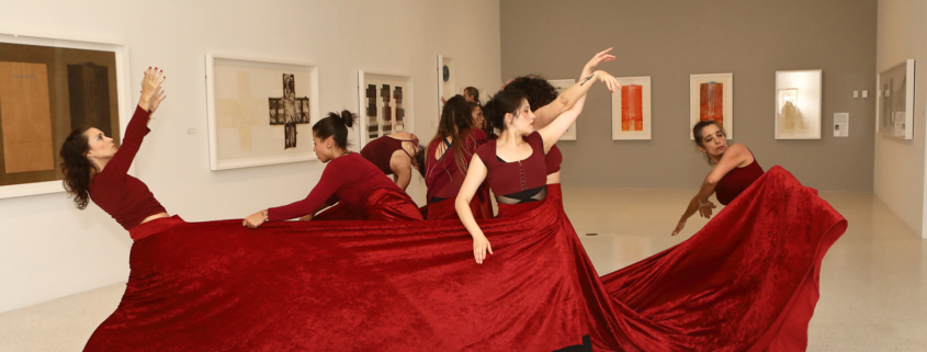 Dancers in red inside museum gallery