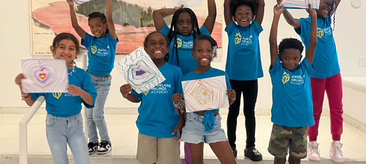Children holding drawings inside the museum